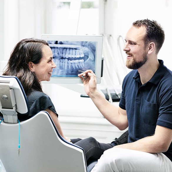 Tandlæge forklarer røntgenbillede til klient